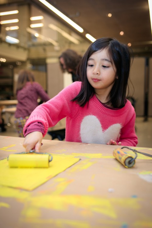 child using paint roller in artmaking class