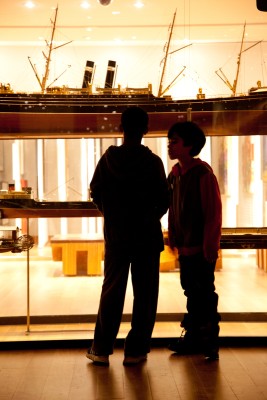 two children looking at ship model