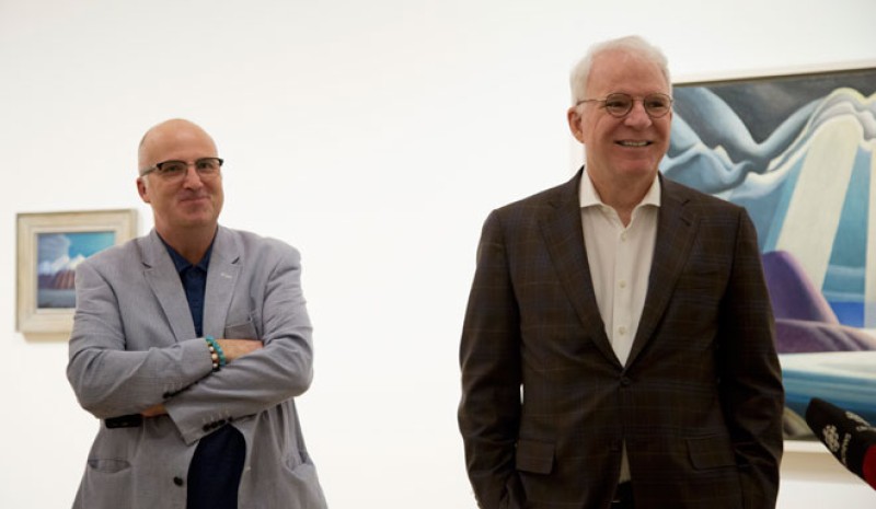 Andrew Hunter and Steve Martin in front of paintings in gallery