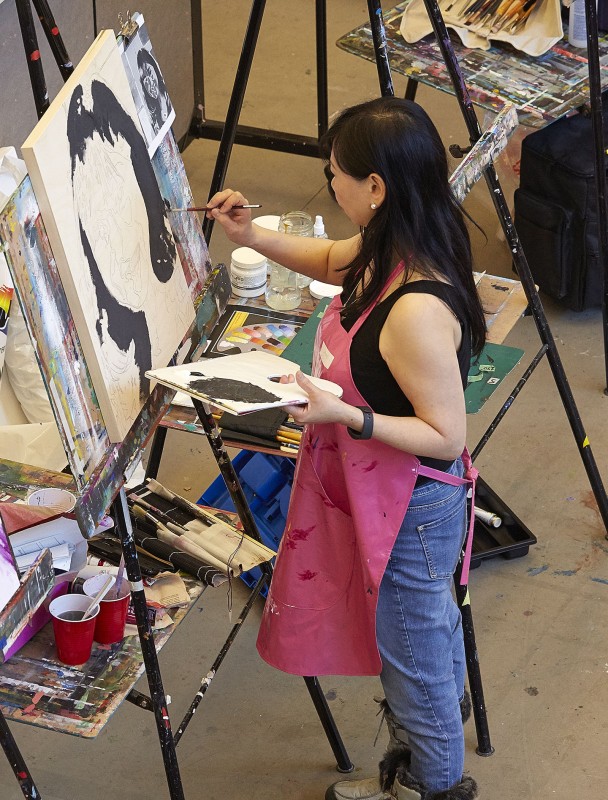 Woman painting portrait at an easel
