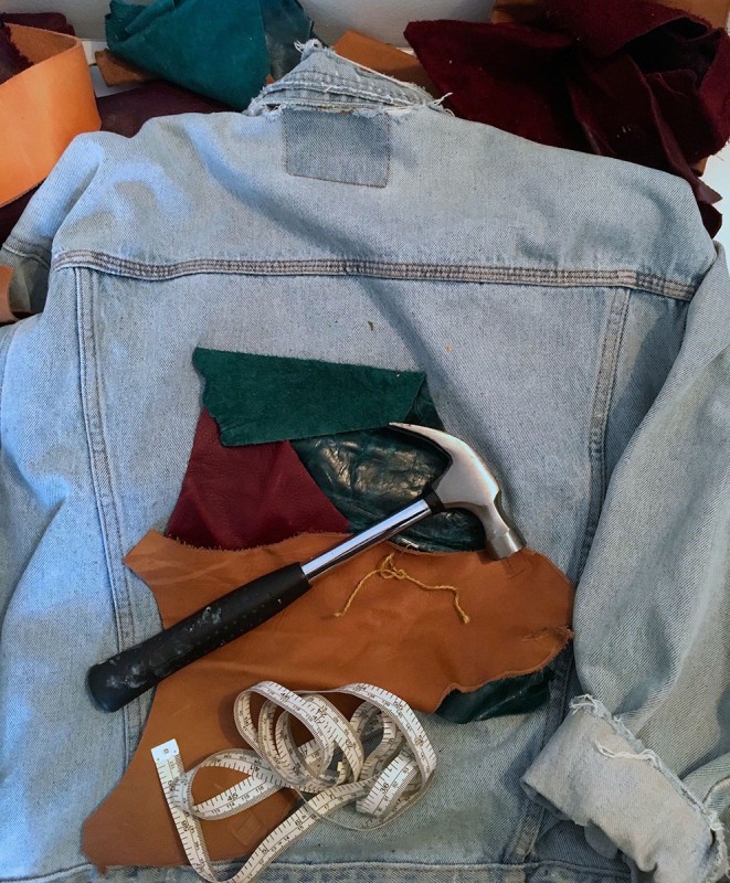 Leather pieces on jean jacket with hammer and measuring tape