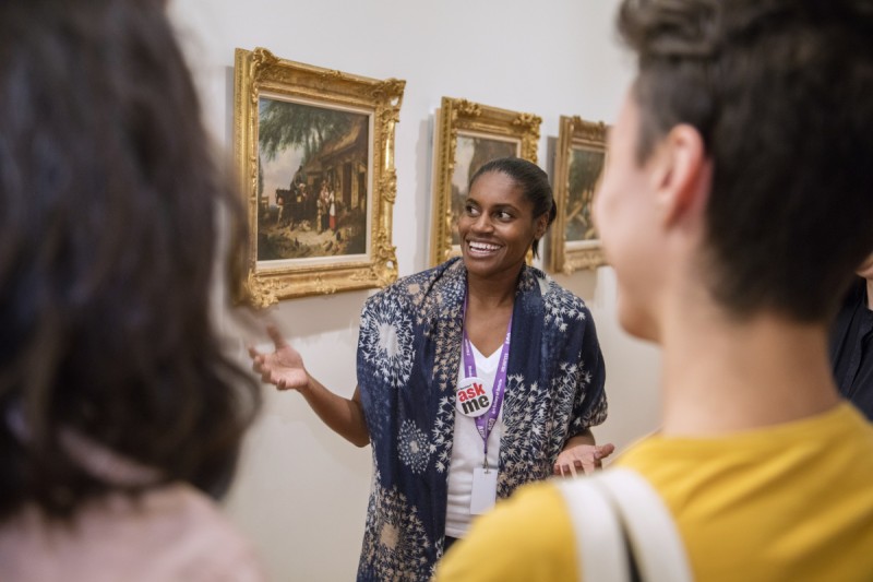 volunteer in front of painting with visitors giving a themed tour