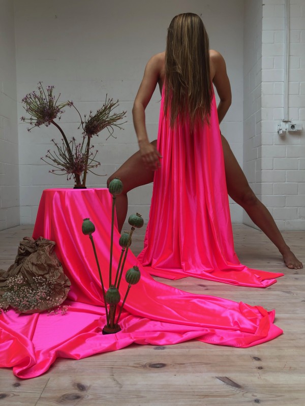 Still of Slow Death performance featuring neon pink satiny fabric