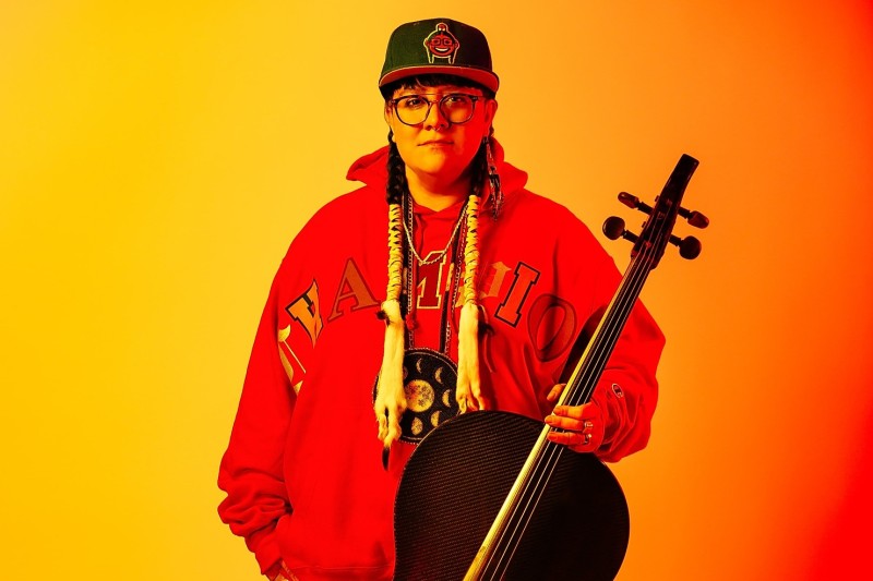 Figure in red hoodie and cello. 