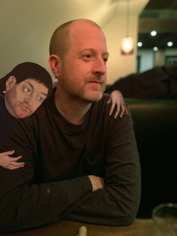 photo of artist James Kerr with an illustrated brown haired-man on his shoulder