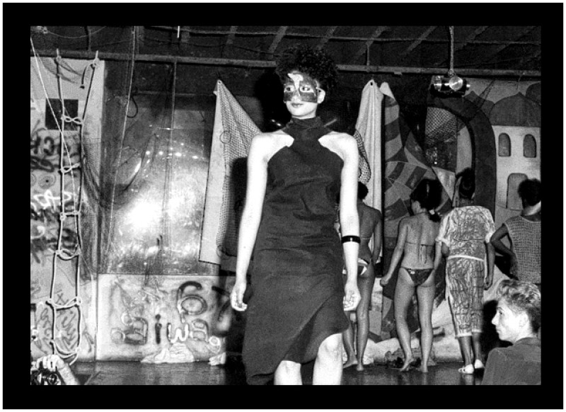 black and white image of a model wearing a dress with shoulder cut-outs and eye maskin a fashion show at Twilight Zone, an afterhours club in Toronto