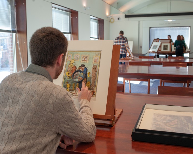 Person in study room looking at print on easel