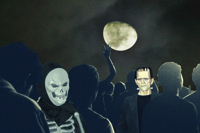 A Halloween scene depicting figures dancing. A person in a skeleton mask and costume can be seen, as well as a Frankenstein mask. 