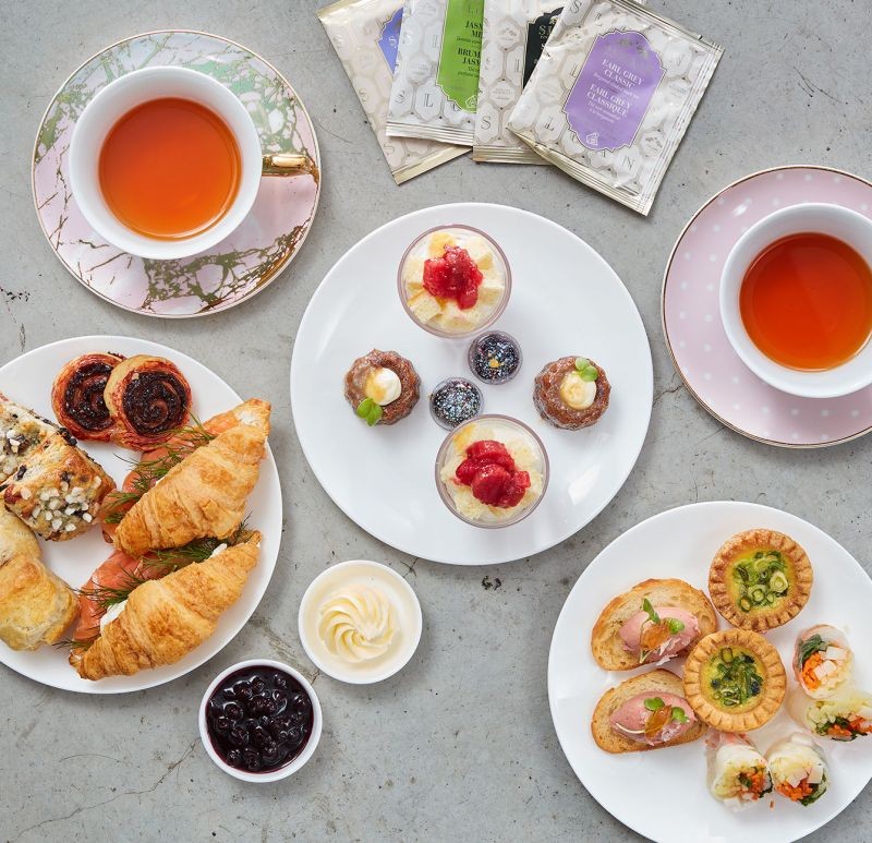 cups of tea and plates with pastries