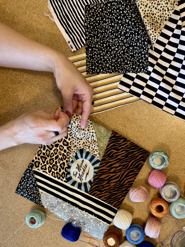 Hands creating a fibre art and textile artwork