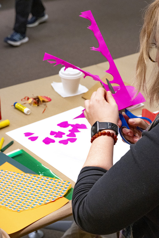 Woman cutting bright pink paper.