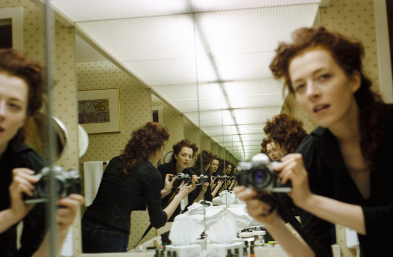 Photo self portrait of a woman in a bathroom mirror with infinite images