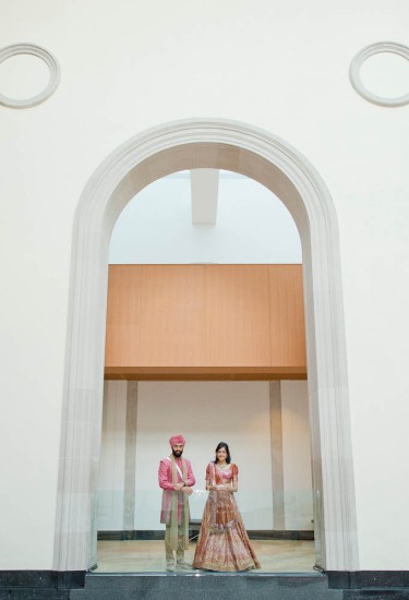 bride and groom standing under archway in Walker Court