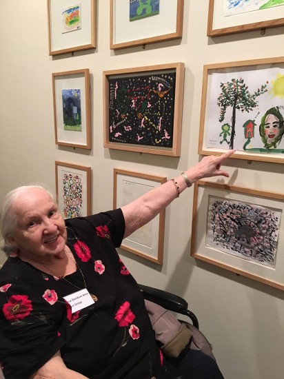 elderly visitor in wheelchair pointing at art work