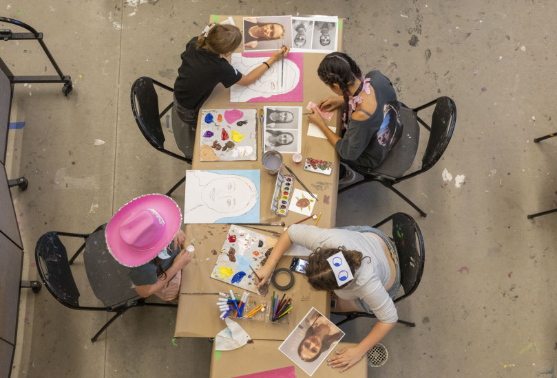 photo taken from above of children painting at a table in the gallery school