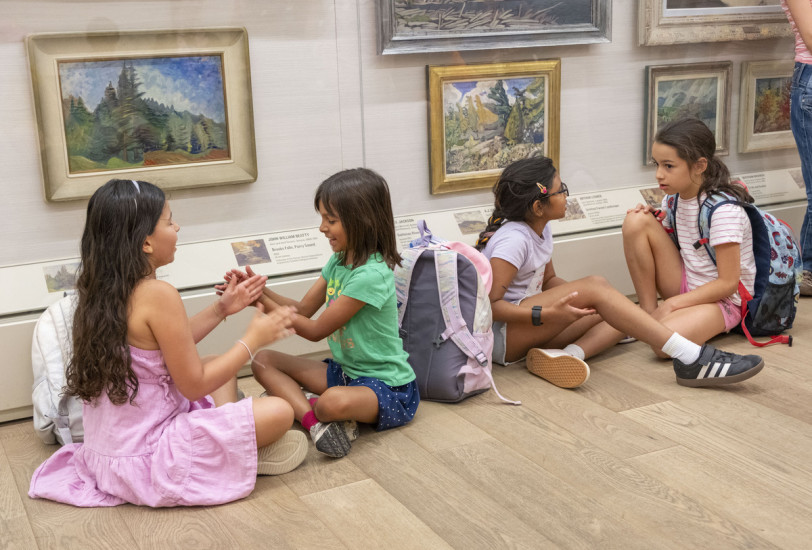 children sitting in front of painting in AGO camp