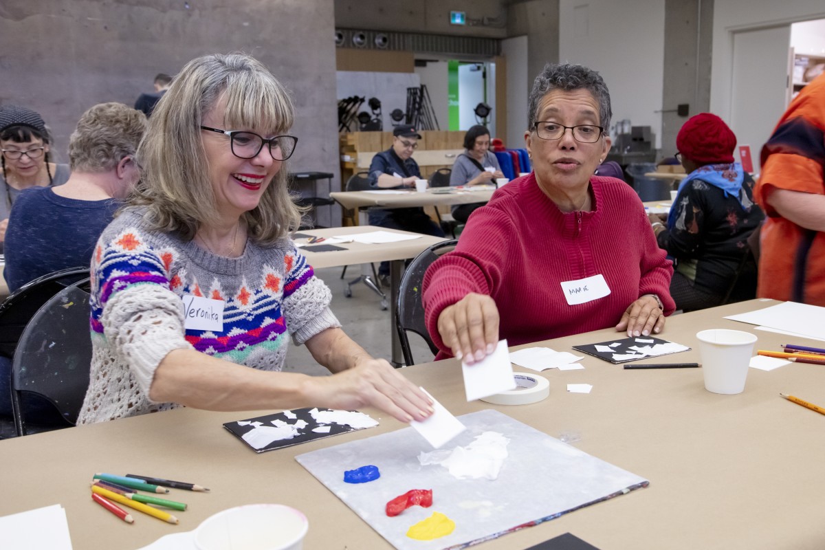 Two women paint using a new technique during the AGO Seniors Social
